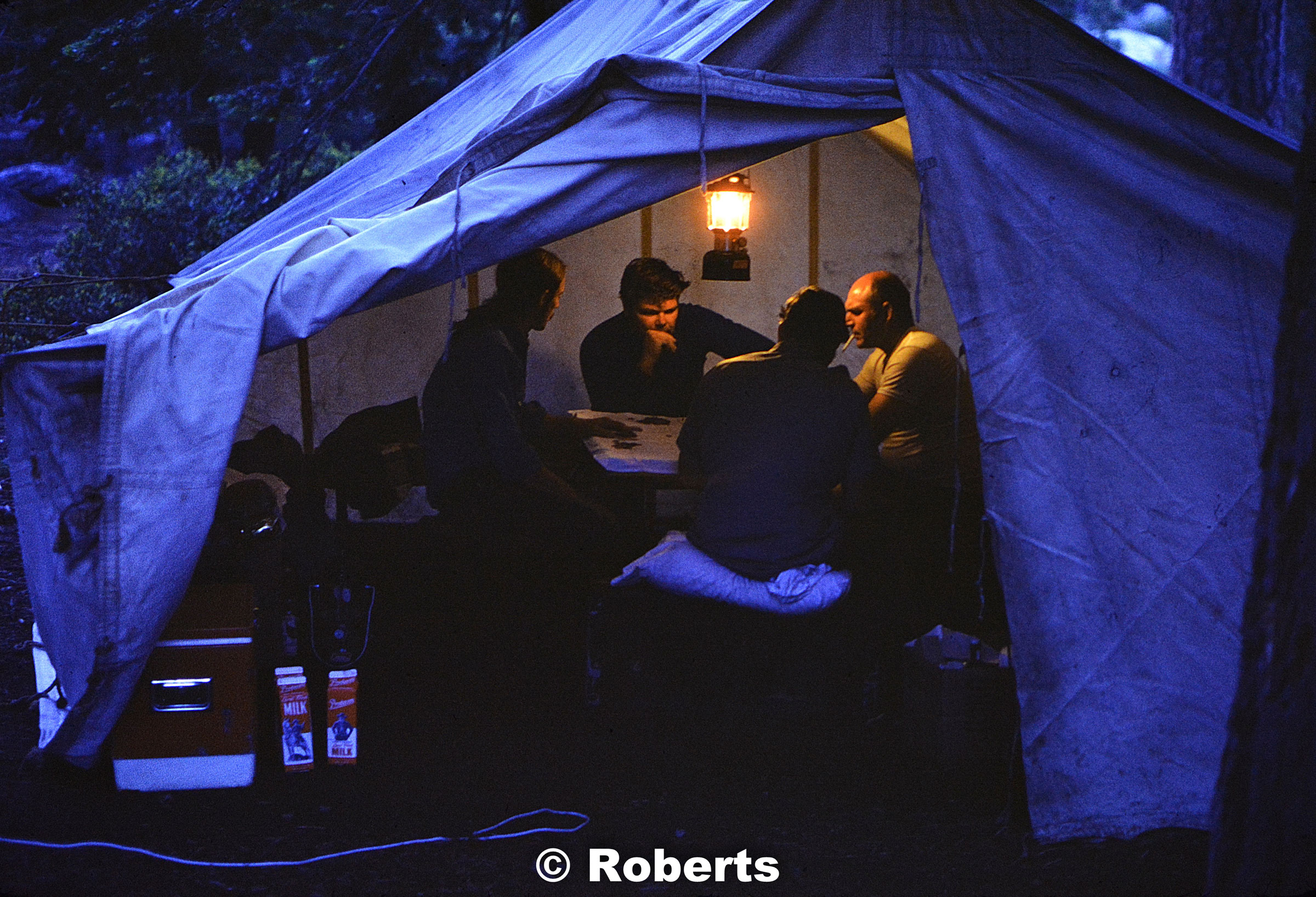 Poker game by lantern light. (L to R): Gary Walters, Art Brooks, Roy Sneed, and Bob Liveoak. Above Yosemite Falls, Yosemite National Park, California. June, 1974.