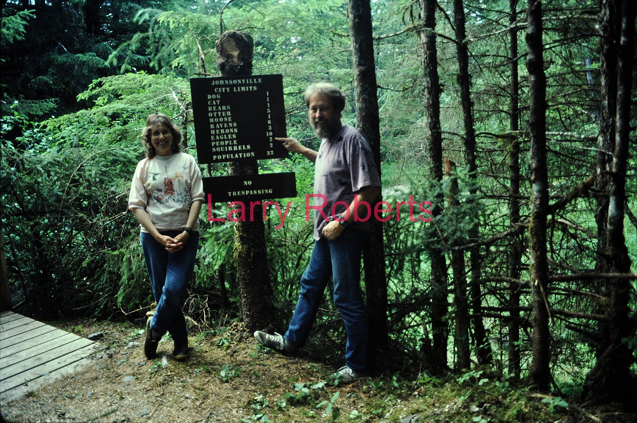Emmalee Blender and Larry Roberts. Johnsonville sign, Kupreanof, Alaska. July 1996.
